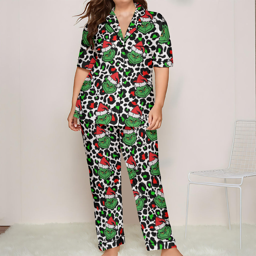 Woman wearing a green and red Grinch leopard print simulated silk pajama set with black piping.